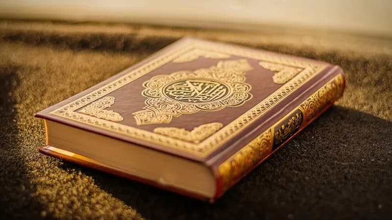 Muslim reciting Quran with prayer beads nearby during evening study